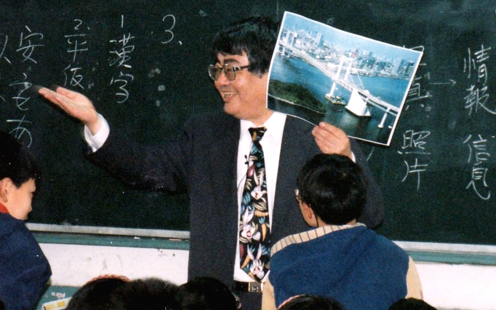Mr. Mukoyama carried out educational exchange projects with various countries, starting with the United States and China.
(Mr. Mukoyama teaching children in Shanghai 1995)